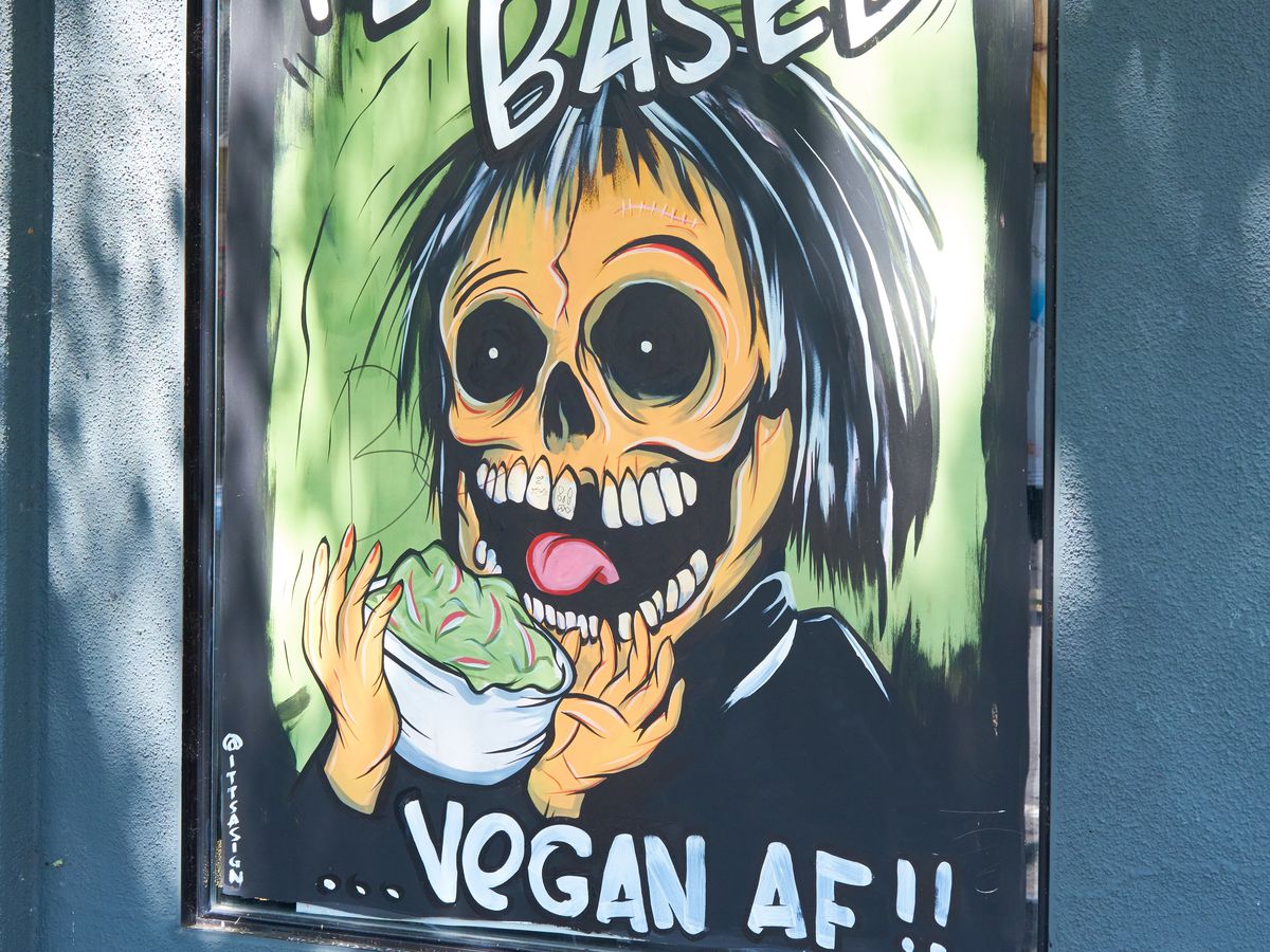 A poster of a skull eating a salad, with the text “Plant based. Vegan AF.”