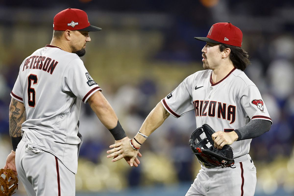 Jace Peterson and Corbin Carroll of the Arizona Diamondbacks celebrate after beating the Los Angeles Dodgers 11-2 in Game One of the Division Series at Dodger Stadium on October 07, 2023 in Los Angeles, California.