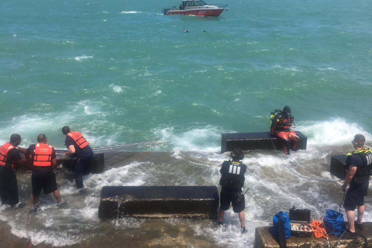 Divers with the Chicago Fire Department search for a swimmer who went underwater July 17, 2020, in Lake Michigan at Promontory Point.