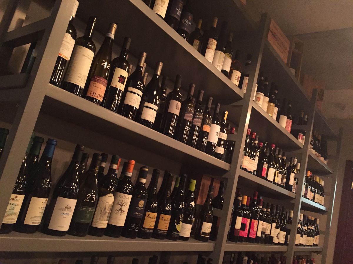 Shelves of wine bottles in a darkened room
