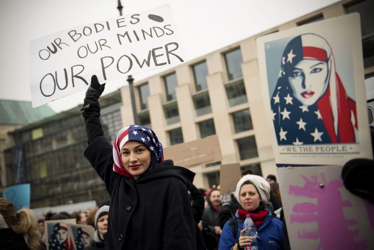 A Woman wearing a USA flag as a headscarf attends a protest for women's rights and freedom in solidarity with the Women's March on Washington in front of Brandenburger Tor on January 21, 2017 in Berlin, Germany.