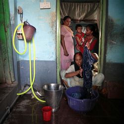 In this May 10, 2012 photo, Fatima Munshi, working as domestic help, washes clothes at a house in Khandwa, India. Living in Australia, Saroo Brierley, 30, reunited with his biological mother, Munshi, in February 2012, 25 years after an ill-fated train ride left him an orphan on the streets of Calcutta. (AP Photo/Saurabh Das)
