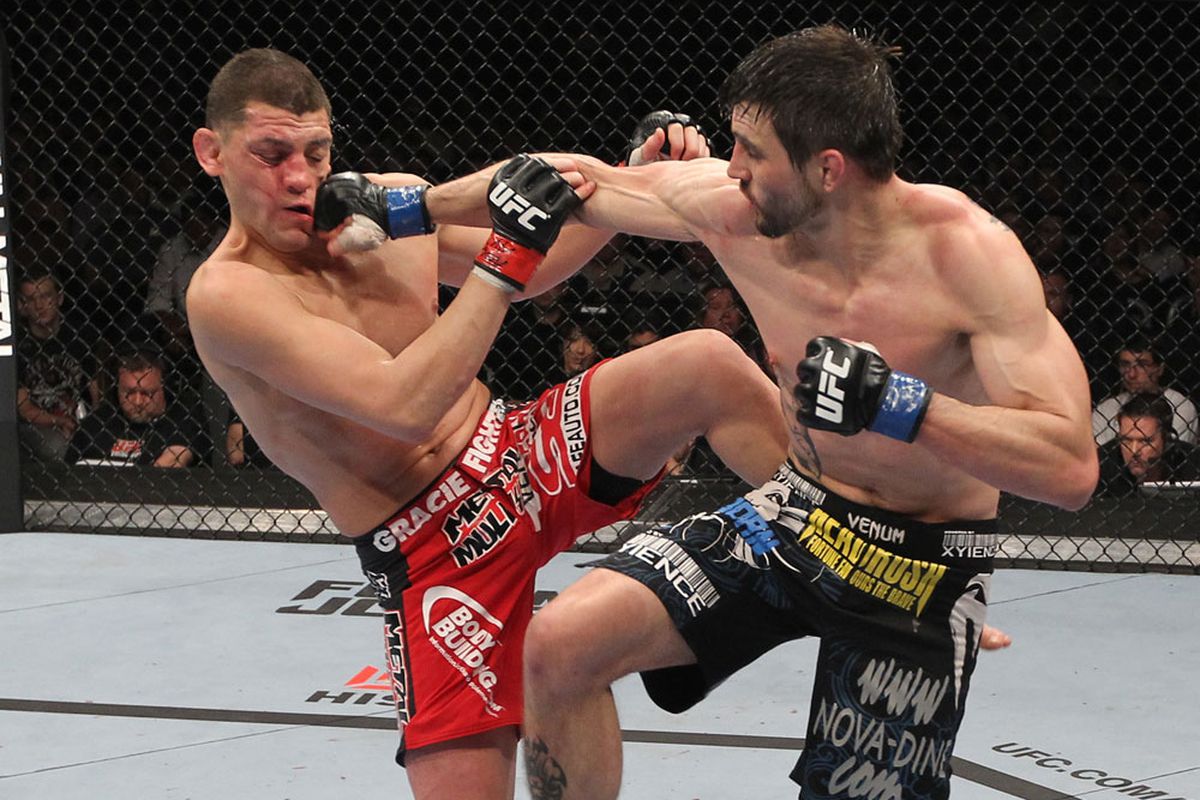 Carlos Condit (right) shouldn't wait for nine months to compete again, says Josh Nason. (Photo: Esther Lin / MMAFighting.com)