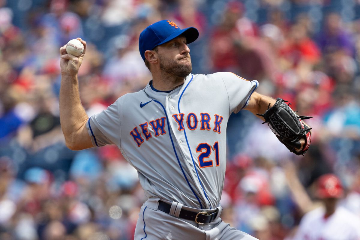 Max Scherzer throws a pitch while wearing a NY Mets jersey