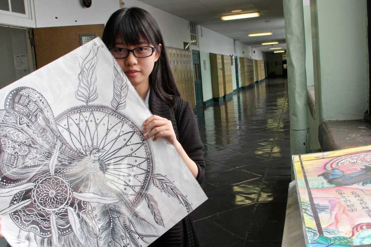 Student holding an illustration.