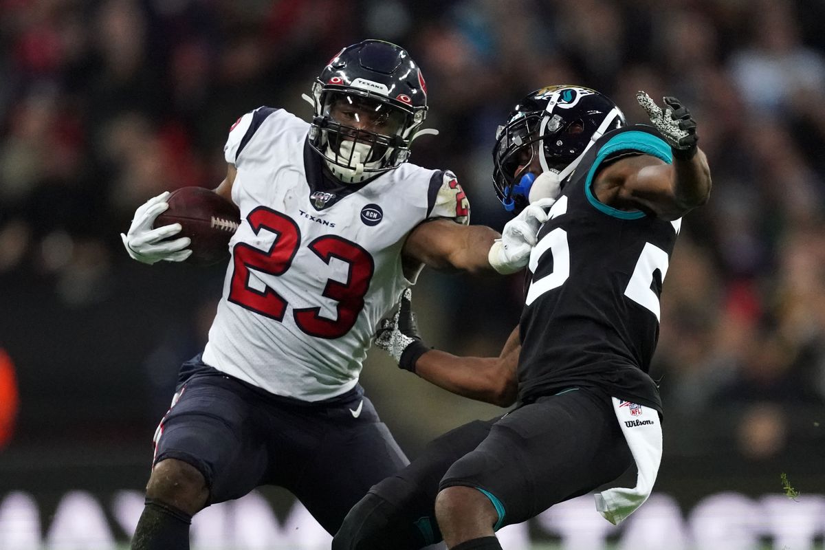 Houston Texans running back Carlos Hyde is defended by Jacksonville Jaguars free safety Jarrod Wilson on a 58-yard run in the third quarter during an NFL International Series game at Wembley Stadium.