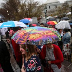 Katelyn Simonsen, of Farmington, stands under an umbrella while waiting to get in to the afternoon session of the LDS Church’s 187th Annual General Conference at the Conference Center in Salt Lake City on Sunday, April 2, 2017.