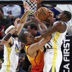 Golden State Warriors center JaVale McGee (1) is charged with a foul as Utah Jazz center Rudy Gobert (27) goes to the hoop between McGee and Golden State Warriors forward Kevin Durant (35) at Vivint Arena in Salt Lake City on Tuesday, Jan. 30, 2018.