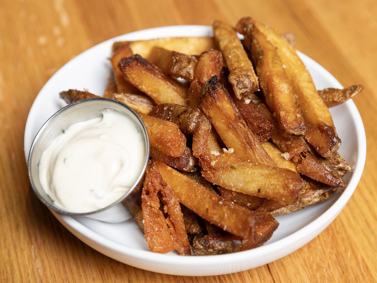 A plate of crispy French fries at Attagirl.