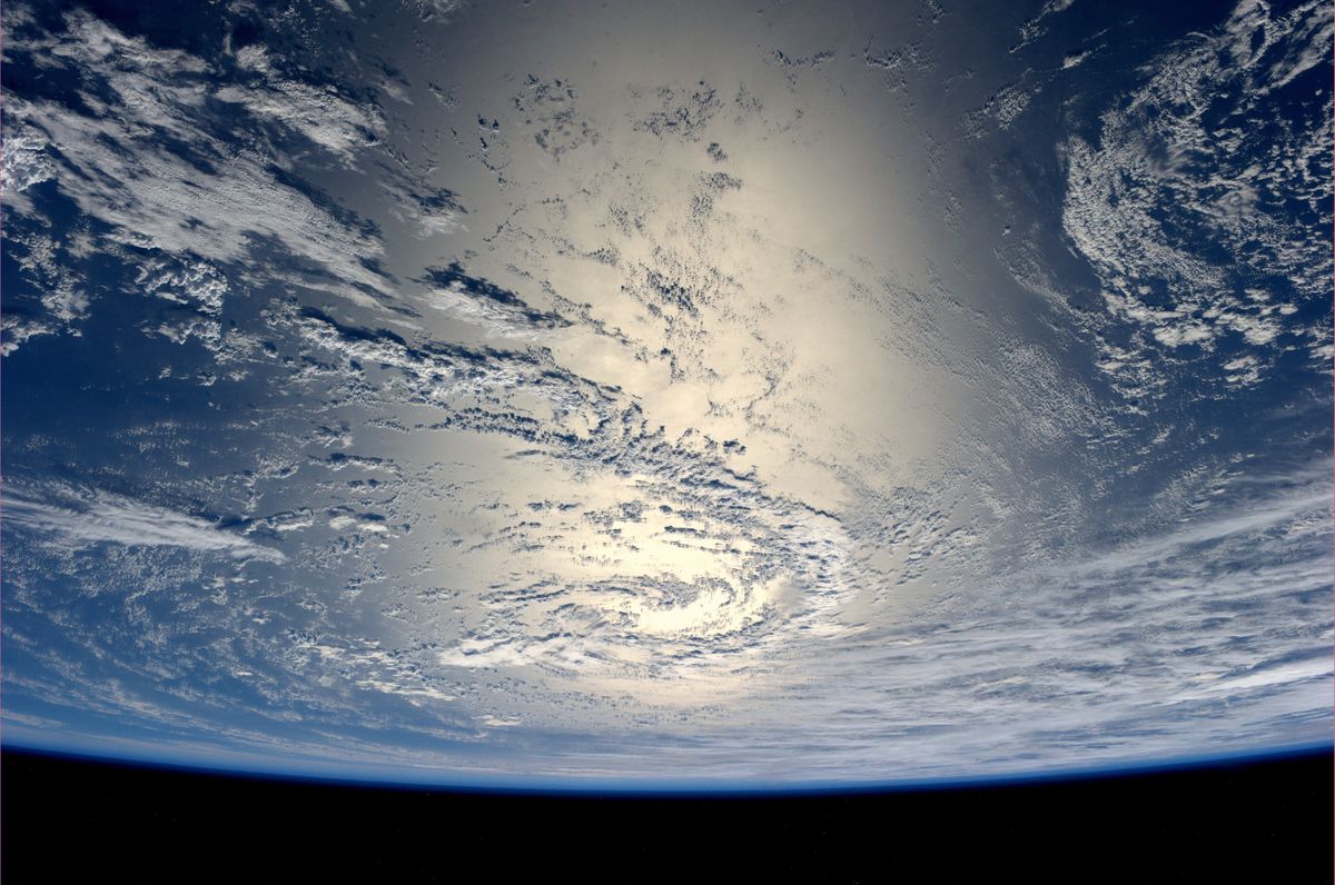 View of the earth from space showing ocean and clouds.
