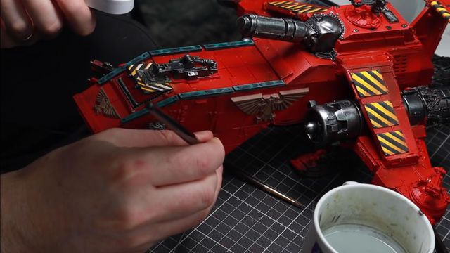 Emil paints fine highlights on the side of a Blood Angels Thunderhawk.