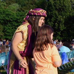 A cast member visits with a young attendee before the presentation of the pageant.