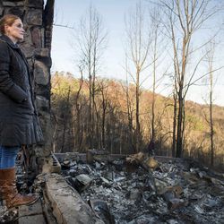 Veronica Carney looks at the skyline from the remains of the home she grew up in, Thursday, Dec. 1, 2016, in Gatlinburg, Tenn. Carney flew in from Massachusetts to assist her parents, Richard T. Ramsey and Sue Ramsey who safely evacuated as a wildfire approached Monday evening. 