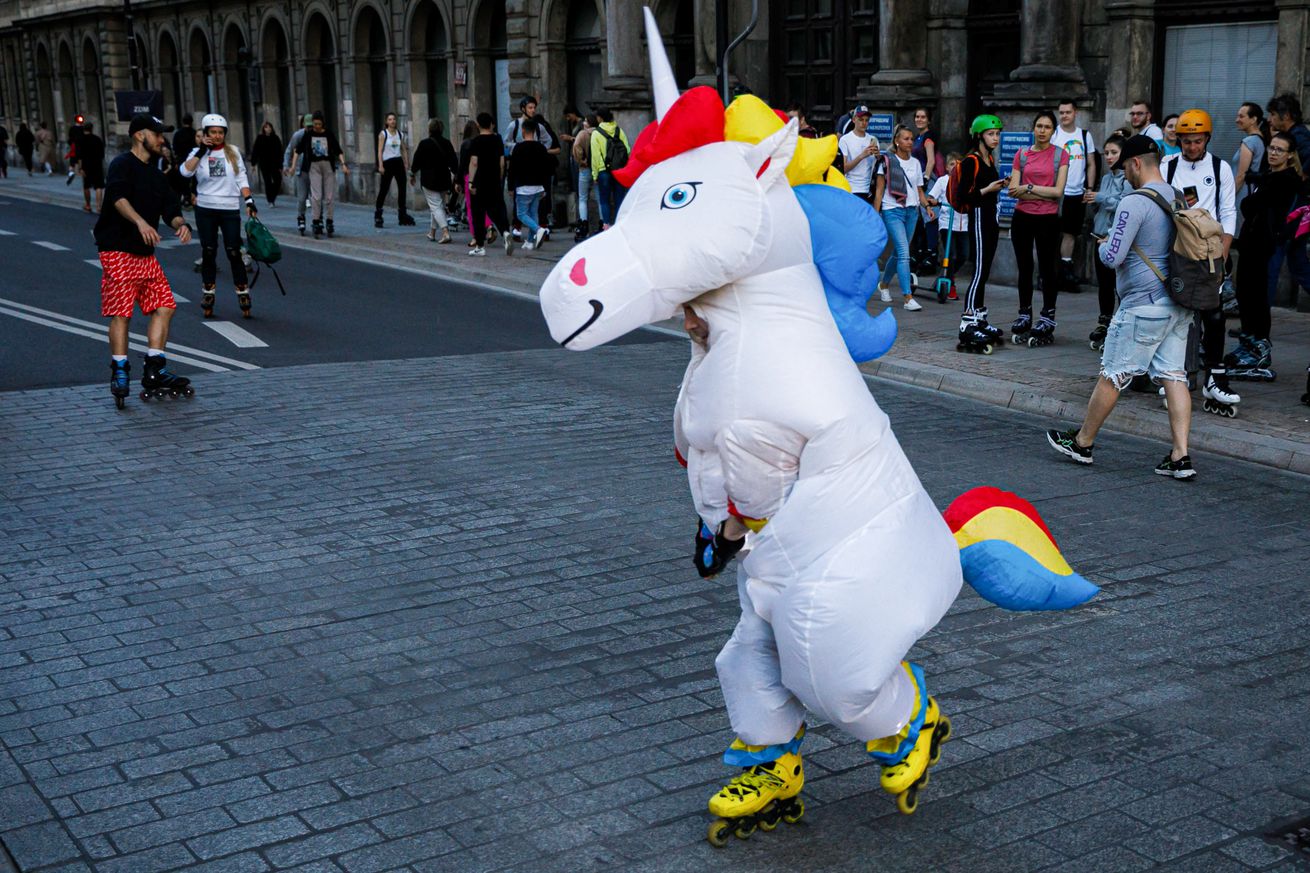 A man wearing a unicorn costume roller skating during the “...