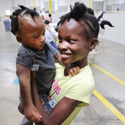 Ehna Elisca, right, tries to get sister Roud Elisca to smile at the Family Transfer Center in Houston on Monday, June 7, 2021.