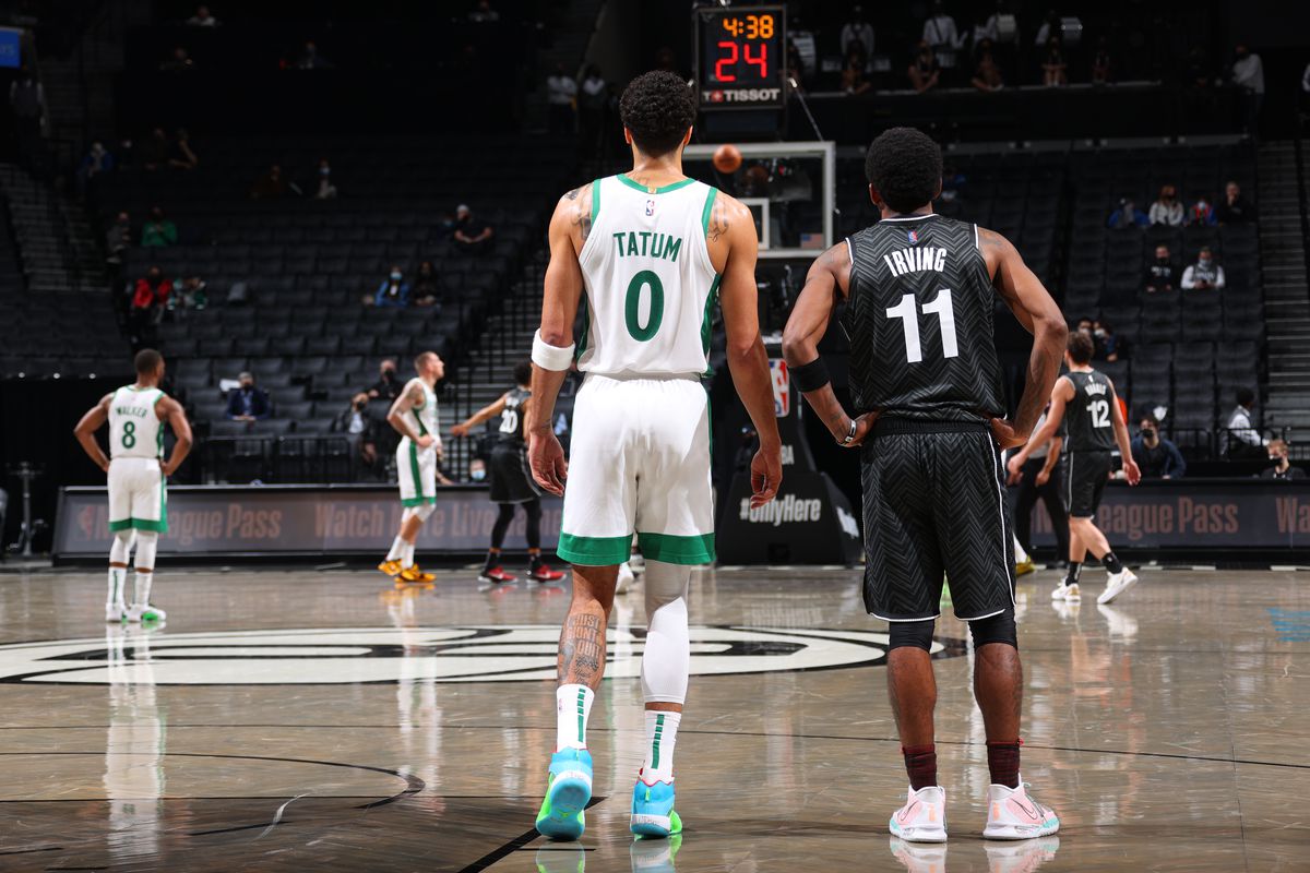 Jayson Tatum of the Boston Celtics and Kyrie Irving of the Brooklyn Nets look on during the game on March 11, 2021 at Barclays Center in Brooklyn, New York.&nbsp;