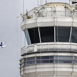 A passenger jet flies past the FAA control tower at Washington's Ronald Reagan National Airport.  