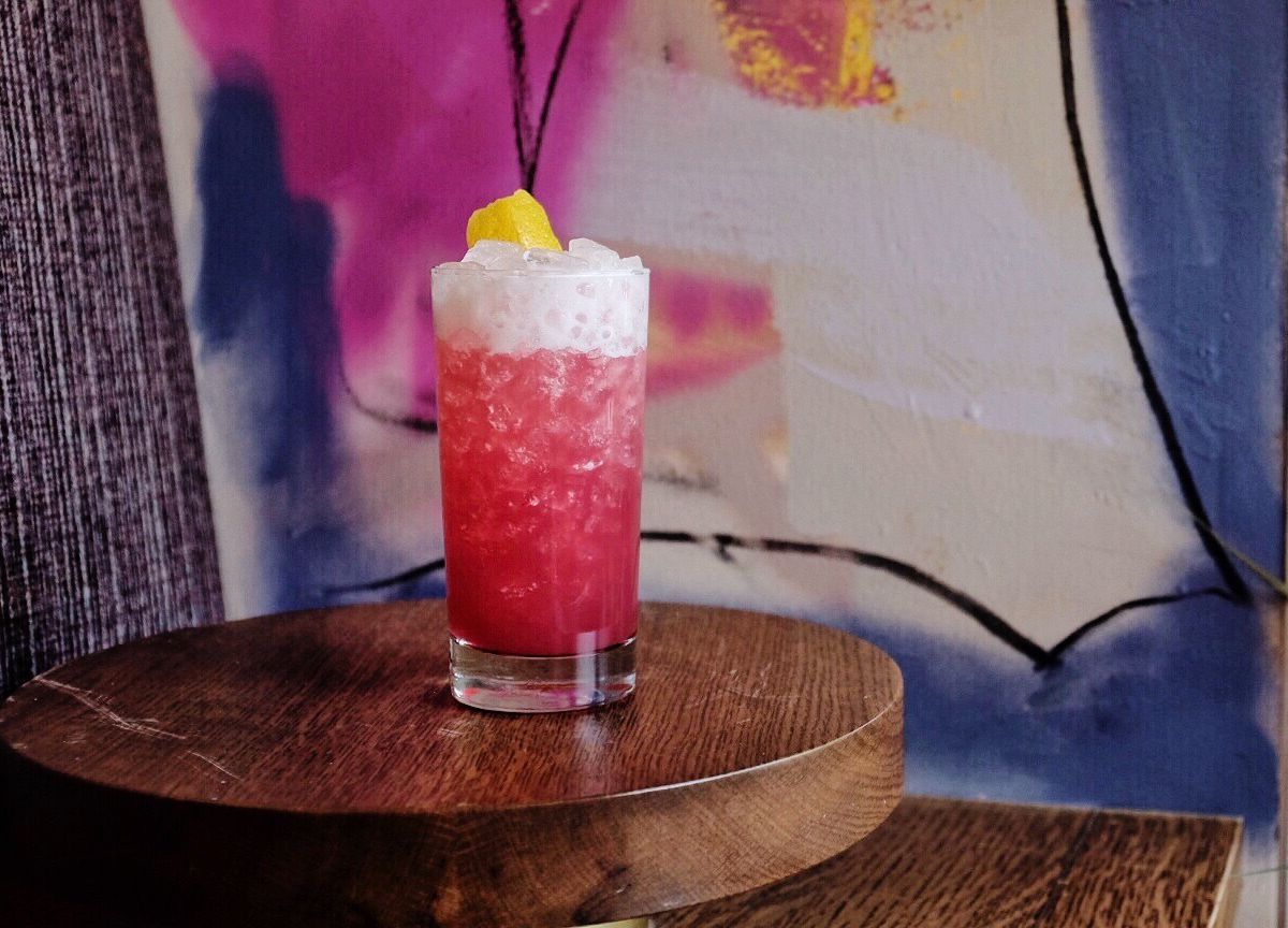 A pink cocktail in a tall glass.