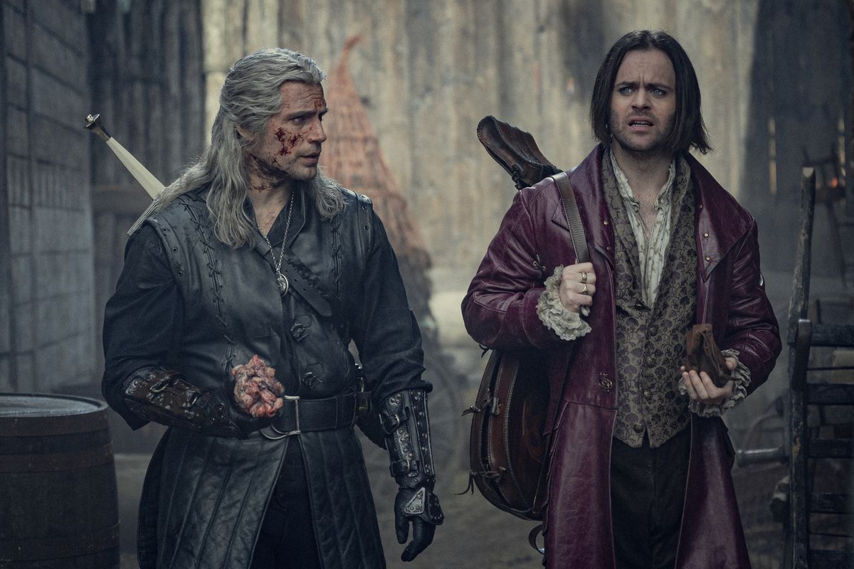 Geralt (Henry Cavill) and Jaskier (Joey Batey) walking in a still from The Witcher season 3 volume 1