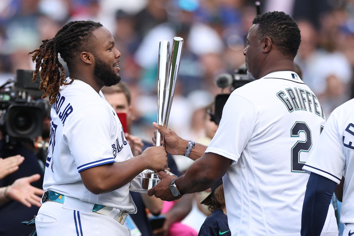 Vladimir Guerrero Jr. #27 of the Toronto Blue Jays is presented the Home Run Derby trophy by Ken Griffey Jr. after winning the T-Mobile Home Run Derby at T-Mobile Park on July 10, 2023 in Seattle, Washington.