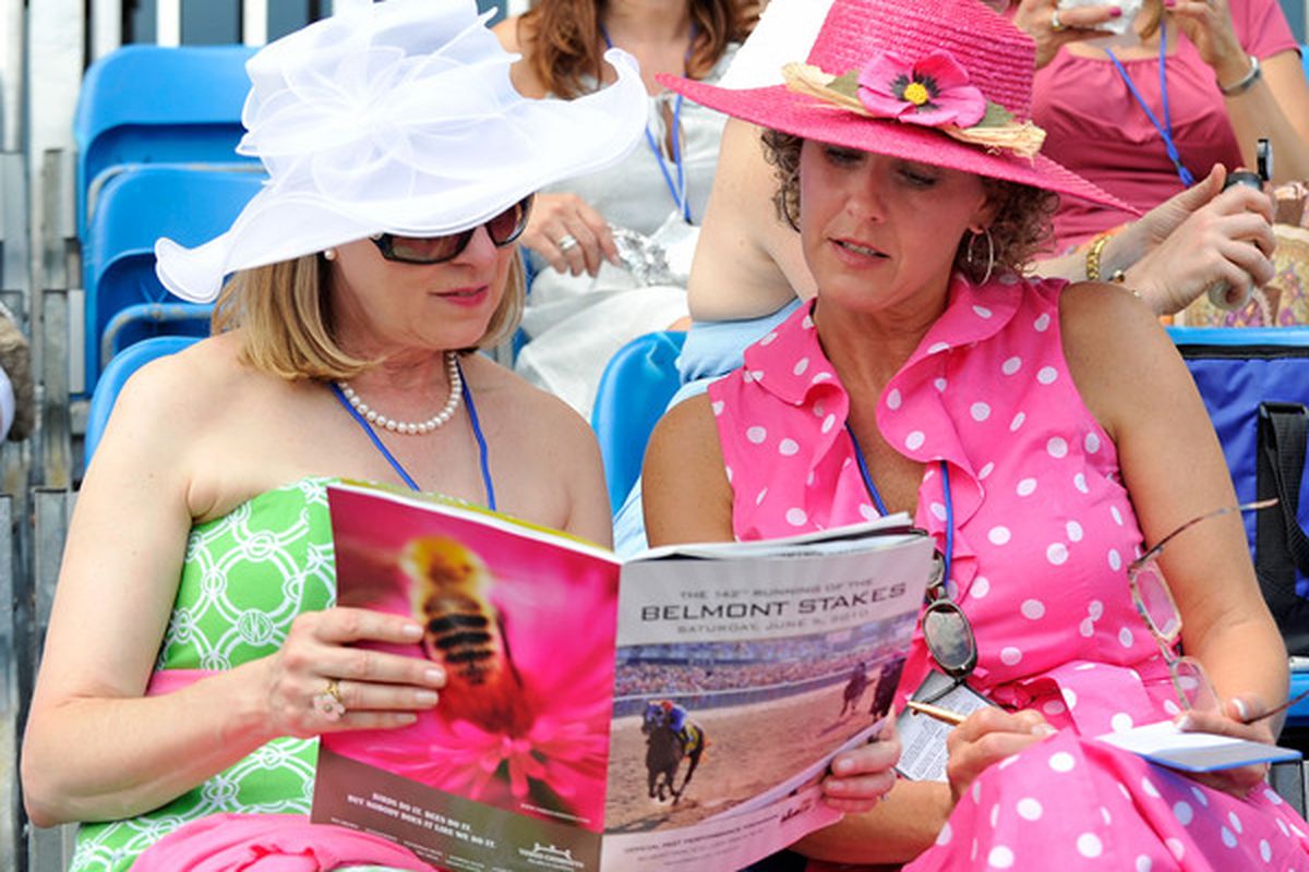 ELMONT, NY - JUNE 05:  Barbara Vilutis and Katrina King of Houston, Texas look over the program today at the running of the 142nd Belmont Stakes at Belmont Park on June 5, 2010 in Elmont, New York.  (Photo by Paul Bereswill/Getty Images)