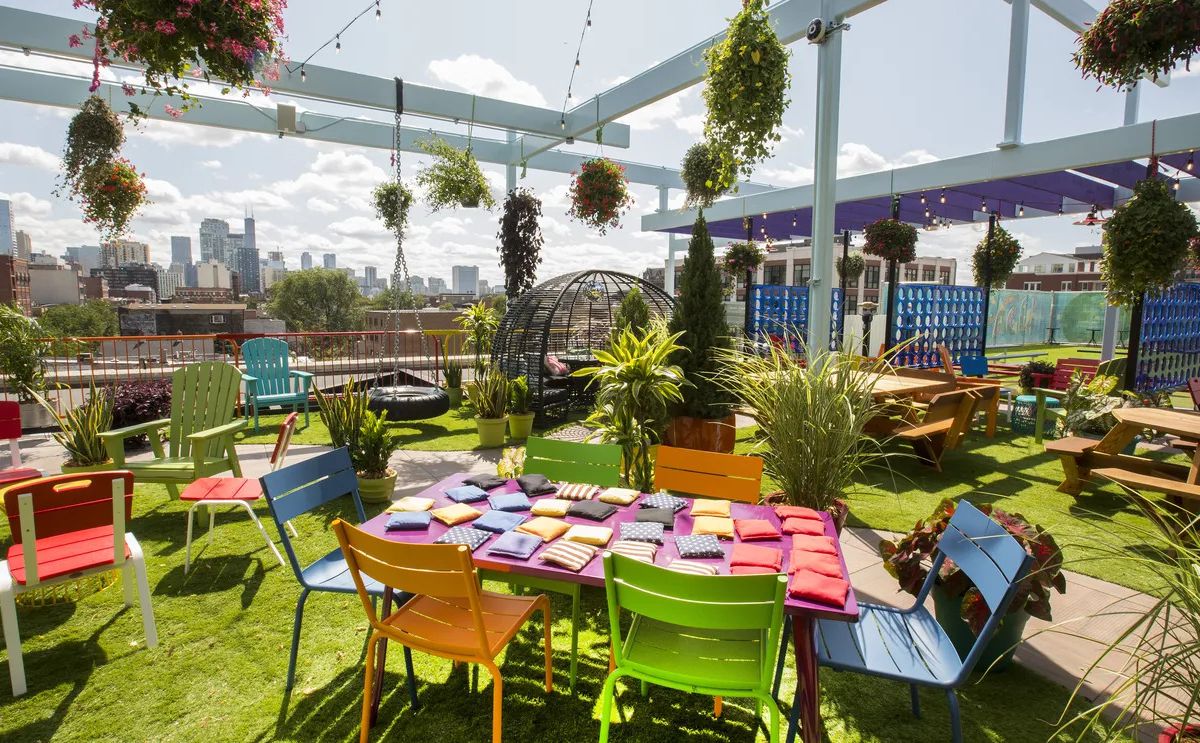 A rooftop restaurant full of colorful furniture and plants.