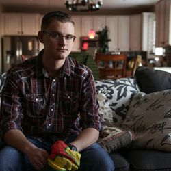 Freeman Stevenson poses for a photo at his father's home in Saratoga Springs on Friday, Dec. 2, 2016. Stevenson, 23, holds a flag from the YPG, or People's Protection Unit, a Kurdish militia he fought with in Syria.