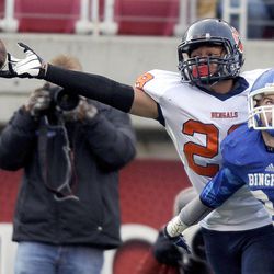 The ball hits the fingertips of Brighton's Sione Heimulii as Bingham's Chase Messervy defends during the 5A State Championships at Rice Eccles Stadium on Friday, November 22, 2013.