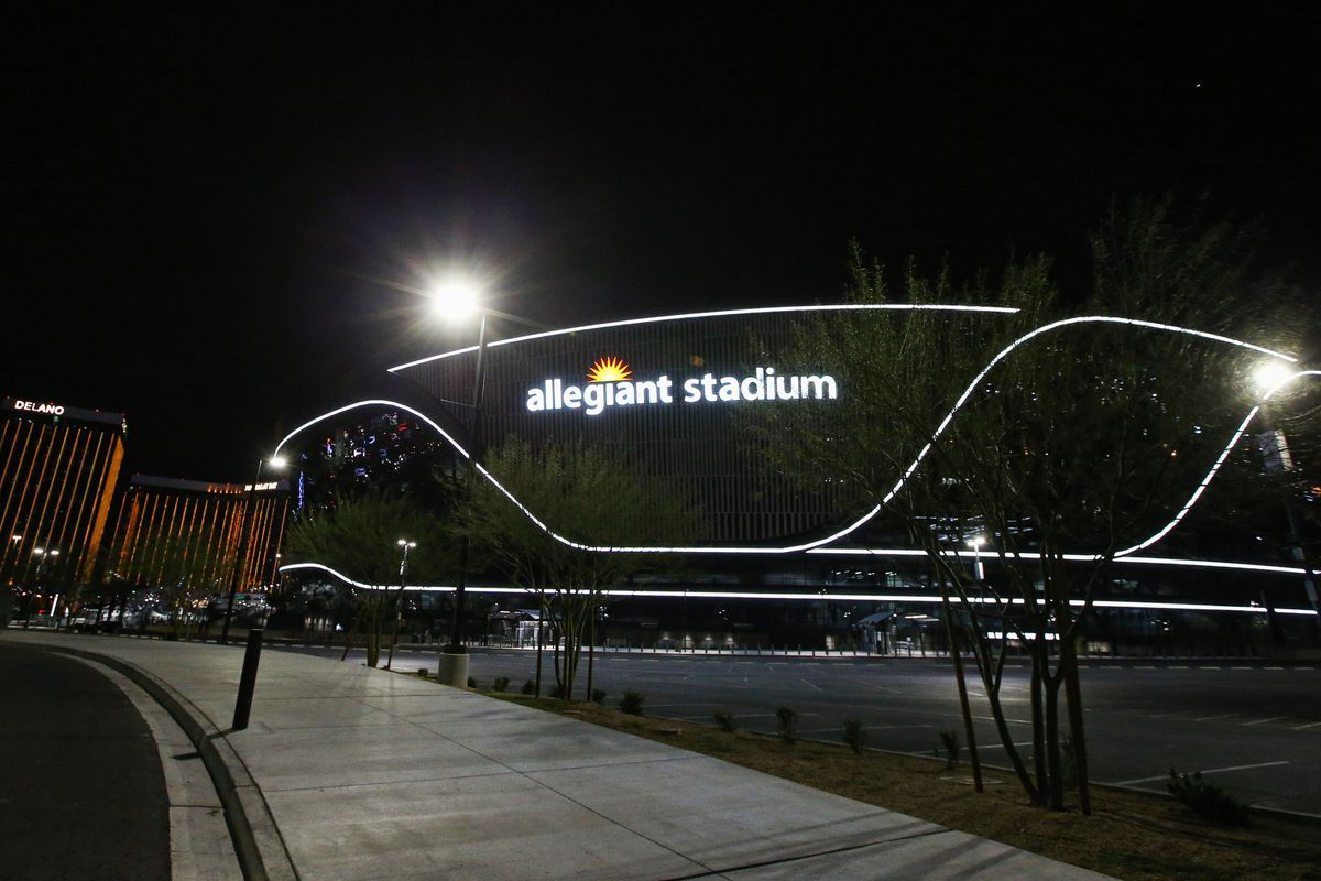 An exterior view of Allegiant Stadium at night with Mandalay...