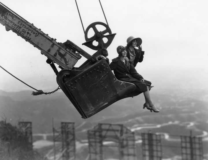 two women are suspended high above the ground as they ride on the shovel from Western&nbsp;ConstructionCo.'s working steam shovel.&nbsp;