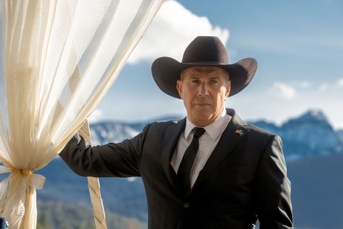 Kevin Costner wearing a black suit and black cowboy hat and facing the camera on Yellowstone