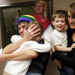 Kim Ludlow hugs Sam Jones at left, with Karina Jones holding Will Jones at right as Kim and Karina finish obtaining a marriage license in Salt Lake County, Monday, Dec. 23, 2013. U.S. District Judge Robert Shelby denied a motion by the state of Utah to halt same-sex marriages pending an appeal.
