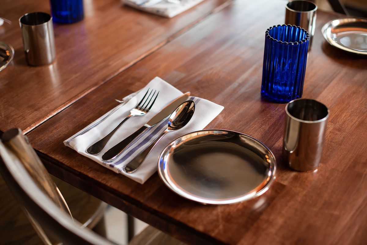 Simple metal plates on a wooden restaurant table.