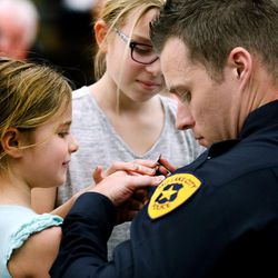Officer Jeff Taylor gets pinned by his daughters Taya, 9, and Brylee, 6, during a Salt Lake City Police Department Academy graduation ceremony at the Pioneer Precinct in Salt Lake City on Friday, March 4, 2016. Fifteen Salt Lake police and two fire department recruits spent 23 weeks training in the police academy. Beginning Monday, the new officers will embark on 15 weeks of field training with veteran officers in order to be certified for solo patrol work. 