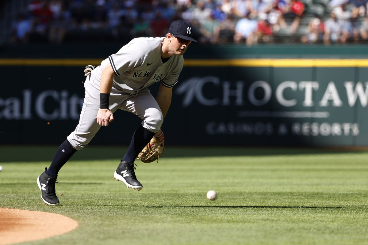 DJ LeMahieu #26 of the New York Yankees attempts to field a single off the bat of Nathaniel Lowe #30 of the Texas Rangers during the first inning at Globe Life Field on October 5, 2022 in Arlington, Texas.