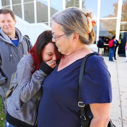 Christina Delgado holds her daughter, Isabella, as parents arrive at Mountain View High School in Orem to pick up their children after five students were stabbed in an apparent attack by a 16-year-old boy on Tuesday, Nov. 15, 2016.