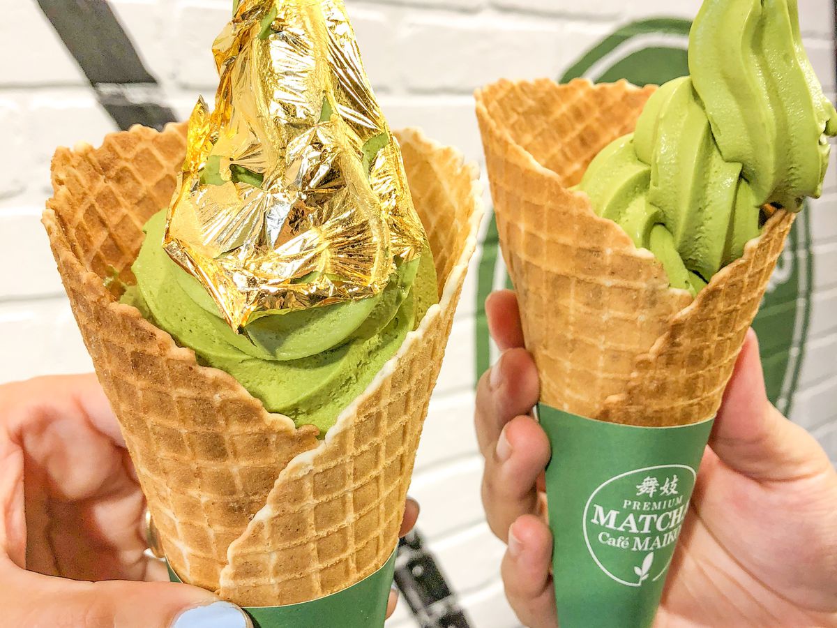Two match soft-serve ice cream waffle cones, one covered with a gold paper layer