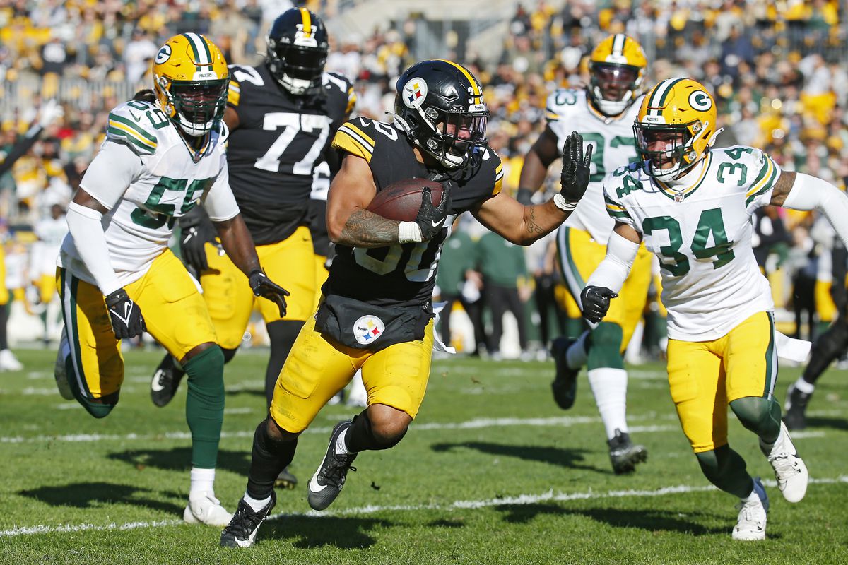 Jaylen Warren #30 of the Pittsburgh Steelers runs past De’Vondre Campbell #59 of the Green Bay Packers and Jonathan Owens #34 of the Green Bay Packers while scoring a rushing touchdown during the second quarter at Acrisure Stadium on November 12, 2023 in Pittsburgh, Pennsylvania.
