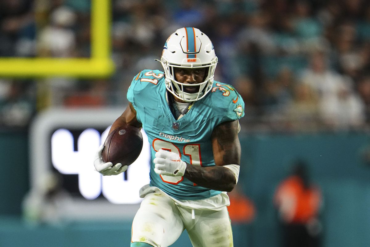 Raheem Mostert of the Miami Dolphins runs the ball during an NFL football game against the Tennessee Titans at Hard Rock Stadium on December 11, 2023 in Miami Gardens, Florida.