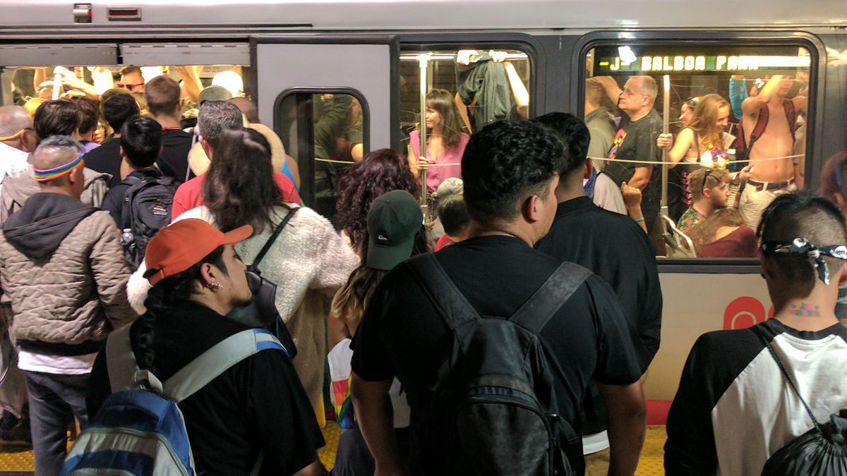 A crowd of people waiting to get on a subway.