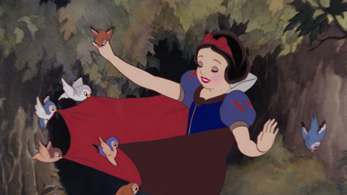 Snow White in Disney’s original animated Snow White and the Seven Dwarfs. She is in the forest and five small birds are pulling at her cape.