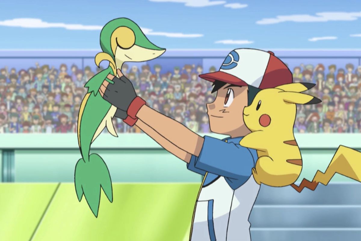 Ash, with Pikachu on his shoulder, holds Snivy up proudly in an arena of people.