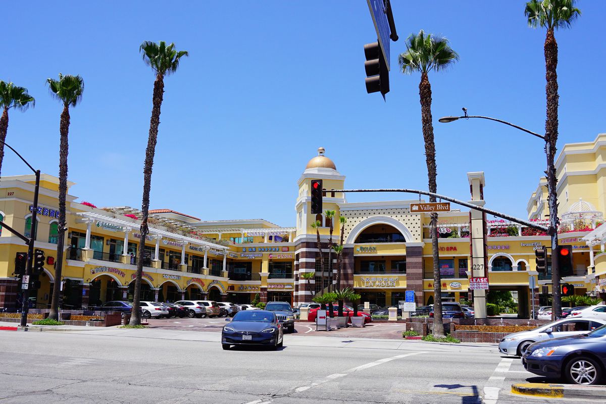 Strip mall with restaurants in San Gabriel, California with palm trees.