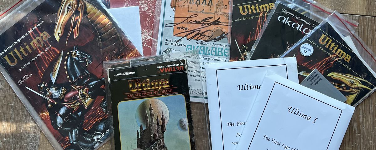 A collection of vintage Ultima games spread out on a hardwood floor