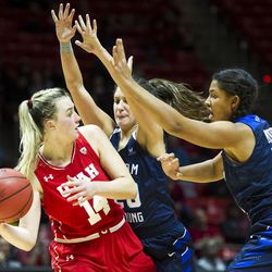 Utah guard Paige Crozon (14) looks to pass around Brigham Young forward Kalani Purcell (32) and guard Cassie Broadhead (20) during an NCAA women's college basketball game in Salt Lake City on Saturday, Dec. 10, 2016. Utah defeated rival Brigham Young 77-60.