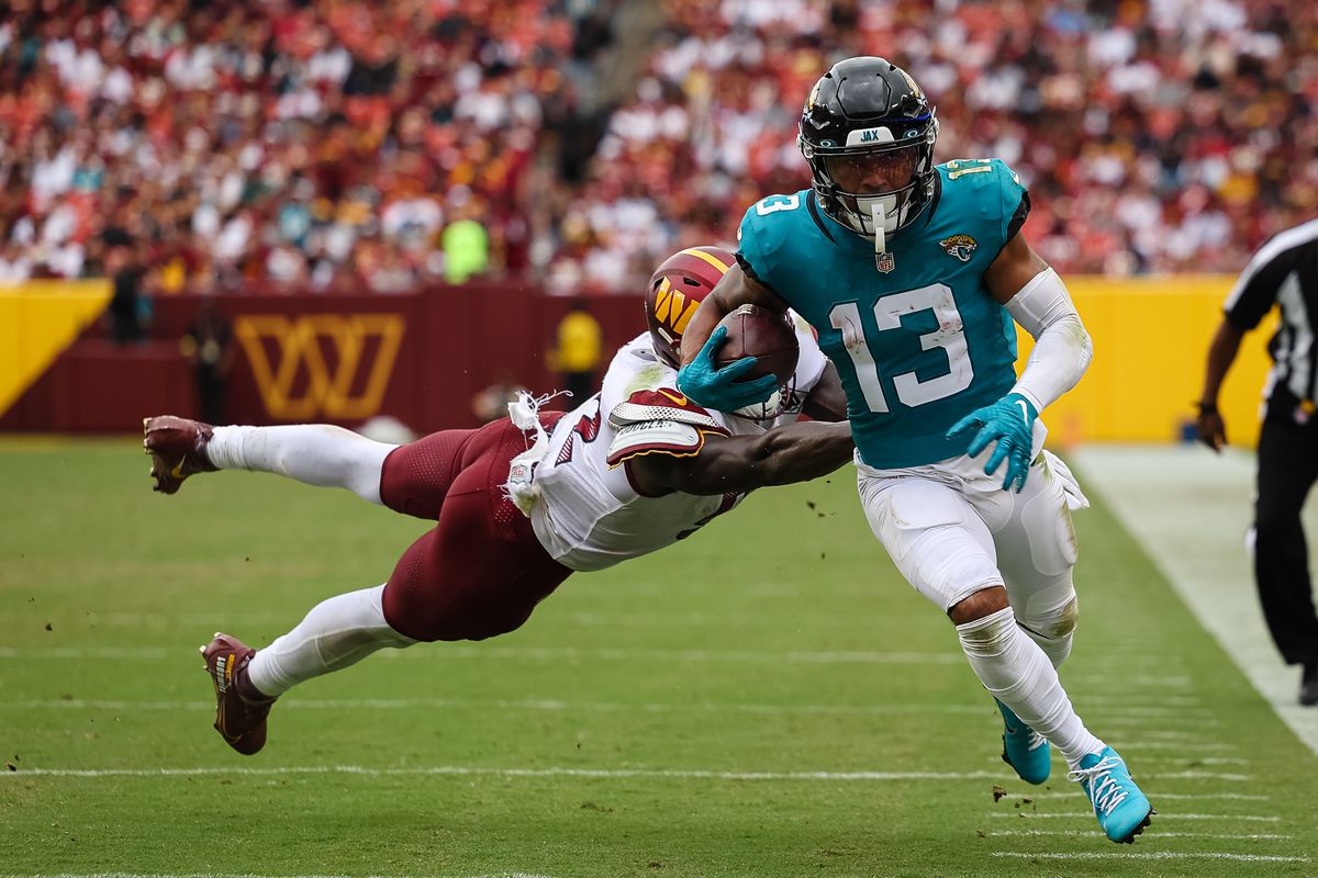 Jacksonville Jaguars wide receiver Christian Kirk (13) runs against the tackle attempt of Washington Commanders linebacker Jamin Davis (52) during the second half at FedExField.