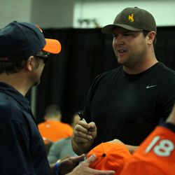 Broncos DT Mitch Unrein signs a hat and talks with fans at the USAA banquet