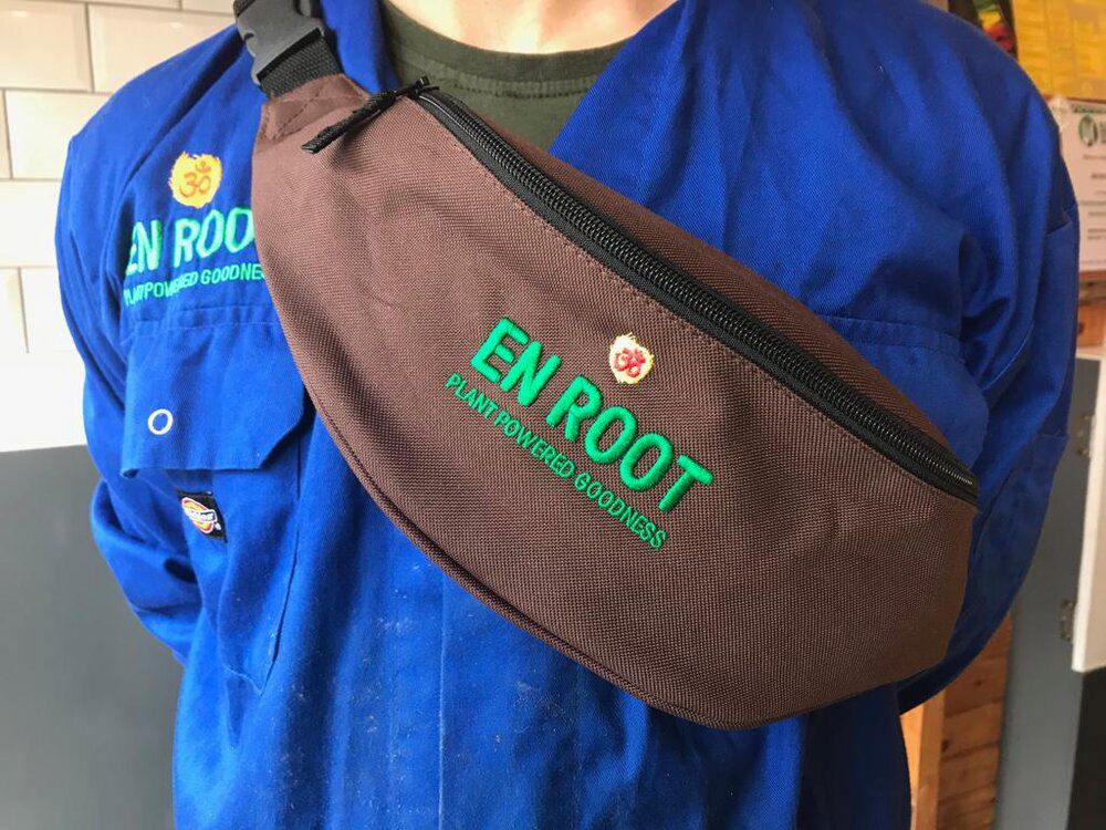 A brown bum bag with green En Root branding text