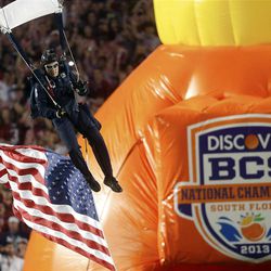 FILE - In this Jan. 7, 2013, file photo, a member of the U.S. Army jumps into the stadium before the first half of the BCS National Championship college football game between Alabama and Notre Dame in Miami. The conference commissioners in charge of putting together the four-team playoff system that will start after the 2014 regular season will meet starting Tuesday, April 23, 2013, in Pasadena, Calif. At the top of their agenda: Pick three more bowls to be used in the semifinal rotation and decide on a site for the first national championship game. (AP Photo/John Bazemore, File)