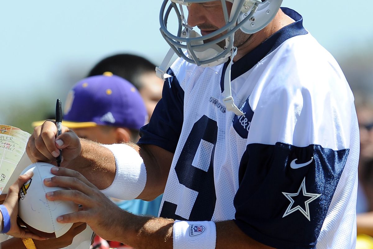 Tony Romo signs autographs in camp.